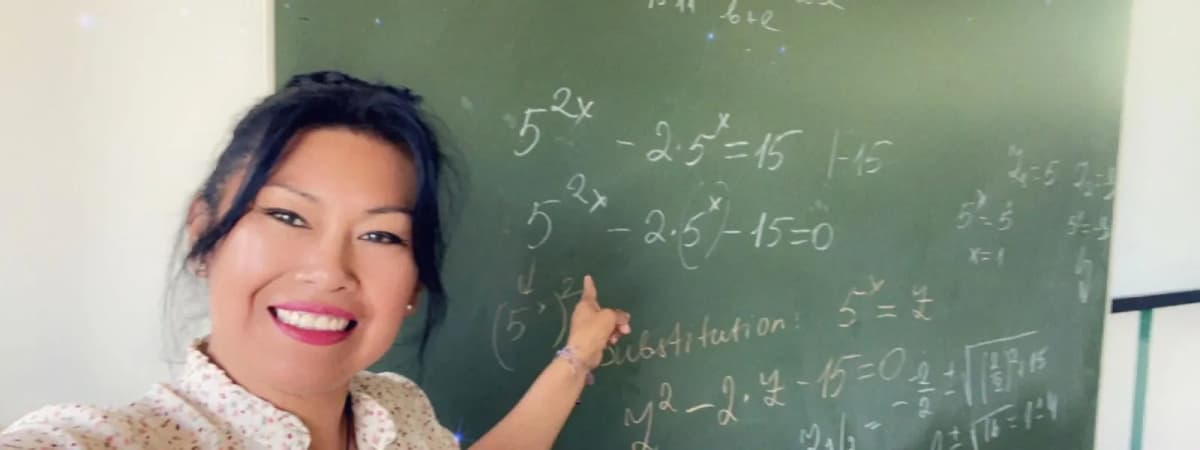 Lucy Peña explicando en la pizarra durante una clase